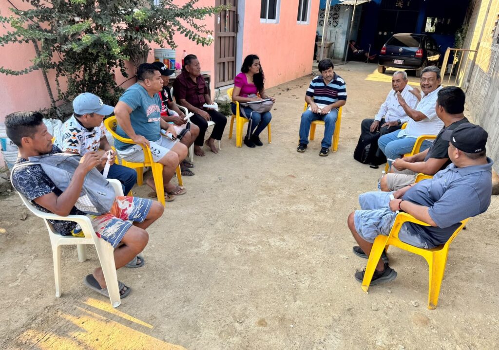 Vecinos sentados en círculo durante una reunión al aire libre en un patio