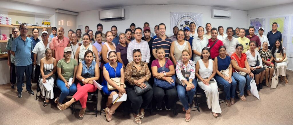 Foto grupal de una reunión numerosa en una sala