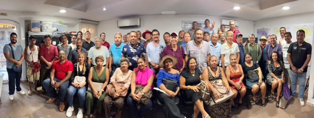 Foto grupal de un grupo ciudadano numeroso en una sala de reuniones