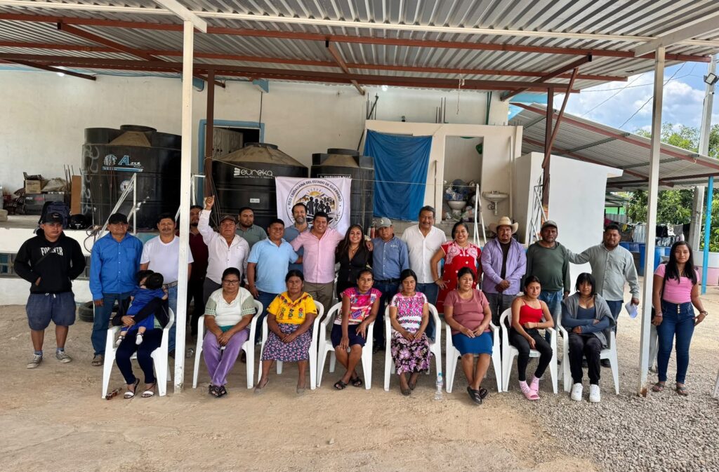 Reunión comunitaria bajo un techo de lámina en un espacio abierto