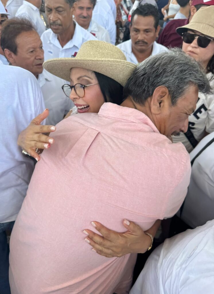 Saludo con un abrazo entre asistentes durante un evento público