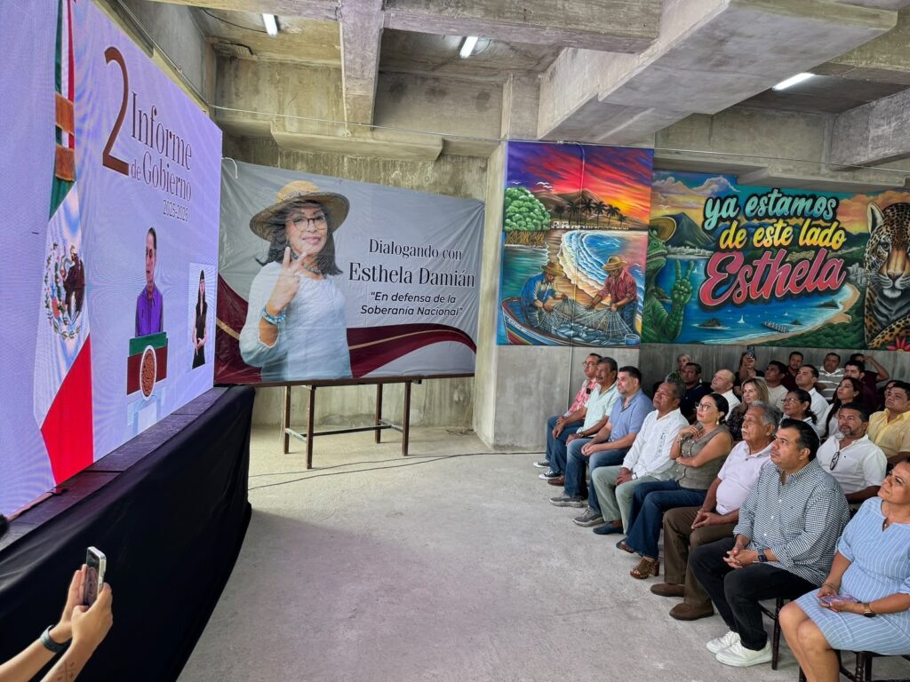 Pantalla con el 2.º Informe de Gobierno junto a la manta «Dialogando con Esthela Damián»